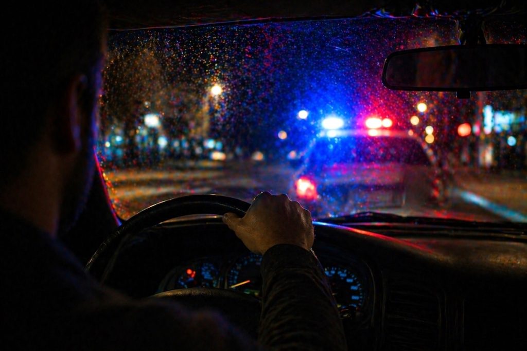 Florida's Super Speeder Law: When a Speeding Ticket Becomes a Criminal Charge Driver pulled over at night with police lights during traffic stop in Miami