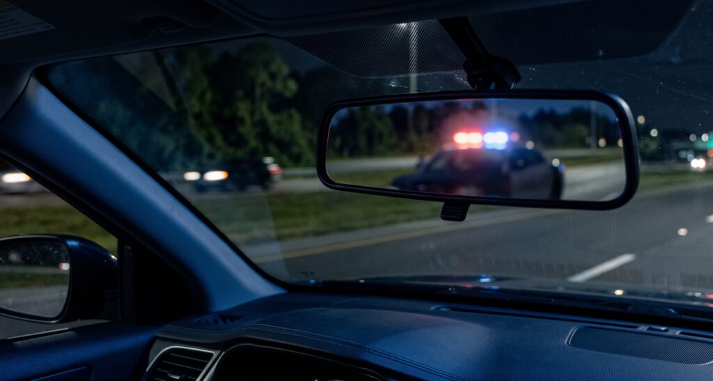 Rearview mirror view of police patrol lights during a Florida traffic stop