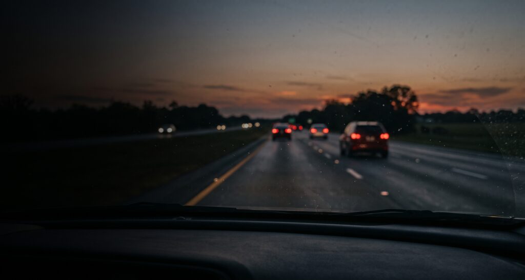 Super Speeder Charge in Miami-Dade: Why a Withhold of Adjudication Is Still a Conviction for Immigration A highway at dusk seen from a car's windshield with blurred taillights ahead